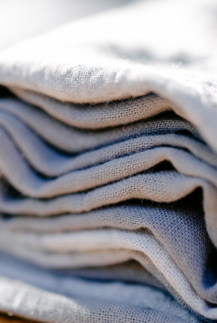 contact-img A close-up of neatly stacked folded linens, showcasing texture and natural fabric.